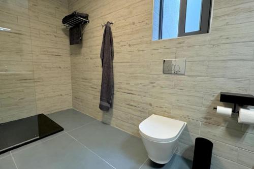 a bathroom with a white toilet and a window at Lux Sea&Country Views with Pool in Mellieħa