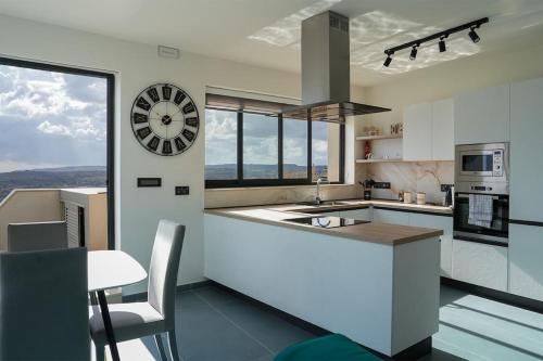a kitchen with a large clock on the wall at Lux Sea&Country Views with Pool in Mellieħa