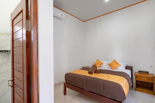 a bedroom with a bed and a door leading into a room at Pratiwi House Lembongan in Nusa Lembongan