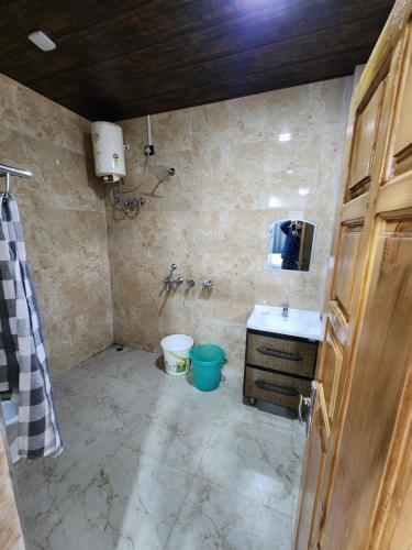 a bathroom with a sink and a toilet at Raithal jungle resort in Bhatwāri