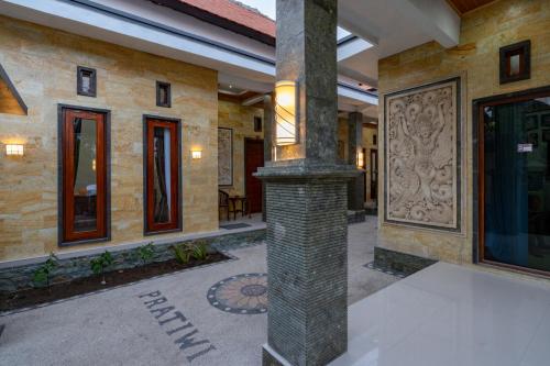 a building with a pillar in the middle of a courtyard at Pratiwi House Lembongan in Nusa Lembongan