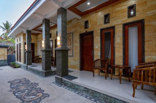 a wooden house with wooden chairs and a porch at Pratiwi House Lembongan in Nusa Lembongan