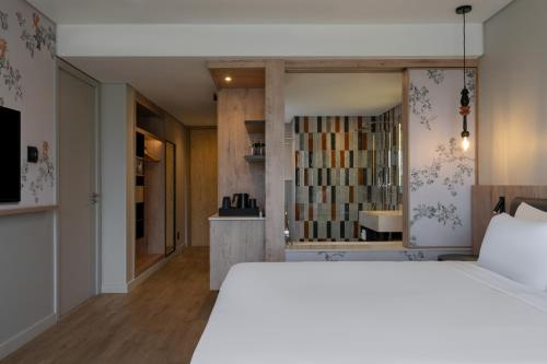 a bedroom with a white bed and a book shelf at Radisson Safari Hotel Hoedspruit in Hoedspruit