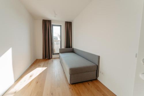 a living room with a couch and a window at RELAX APARTMENTS An der Lage Hochgraßnitzberg in Spielfeld