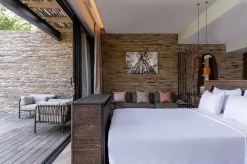 a bedroom with a bed and a couch at Radisson Safari Hotel Hoedspruit in Hoedspruit