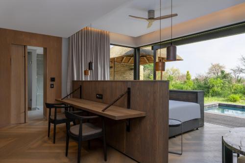a bedroom with a bed and a dining room with a table at Radisson Safari Hotel Hoedspruit in Hoedspruit