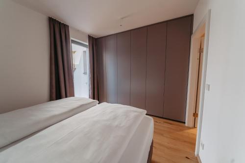 a bedroom with two white beds and a closet at RELAX APARTMENTS An der Lage Hochgraßnitzberg in Spielfeld