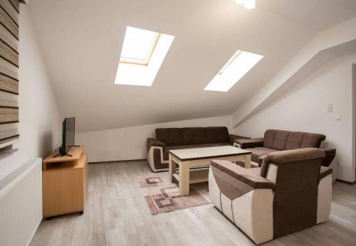 a living room with a couch and a table and a tv at Ivana Apartmani in Tomislavgrad