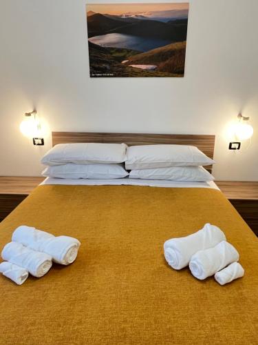 1 dormitorio con 2 camas y toallas blancas. en Appartamento Tufo - 10min dalla Rocchetta Mattei, en Vergato