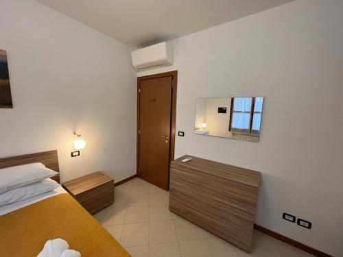 Habitación de hotel con cama y espejo en Appartamento Tufo - 10min dalla Rocchetta Mattei, en Vergato