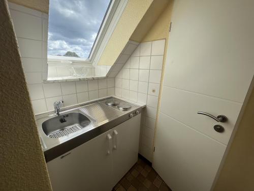 a small bathroom with a sink and a window at STOE 14b Gästehaus Iden, App 2 in Niendorf