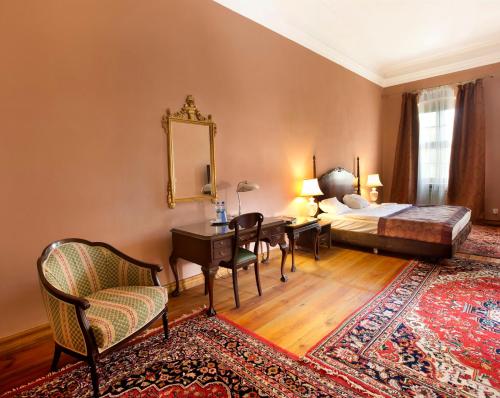 1 dormitorio con cama, escritorio y espejo en Pałac Wiechlice - Hotel, Restaurant, SPA, en Szprotawa