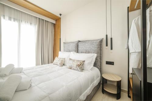 a bedroom with a large white bed and a window at Nikon Boutique Hotel in Kalamaki