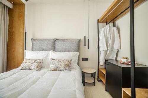 a bedroom with a large white bed with two pillows at Nikon Boutique Hotel in Kalamaki