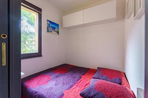 - une petite chambre avec un lit et une fenêtre dans l'établissement Oldeto - Appt climatisé avec piscine partagée, à Bandol