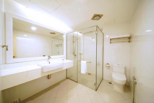 a bathroom with a sink and a toilet and a mirror at Permai Hotel Kuala Terengganu in Kuala Terengganu