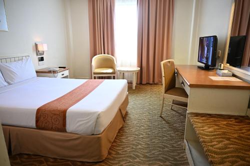a hotel room with a bed and a desk at Permai Hotel Kuala Terengganu in Kuala Terengganu