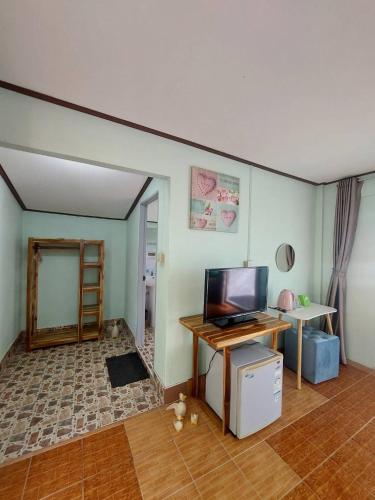 a living room with a flat screen tv and a table at Phi Phi View Point Resort in Phi Phi Don
