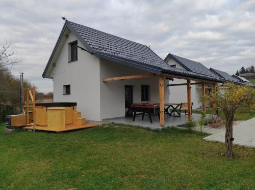 a small white house with a solar roof at Zatoka Perska - dom Francuz z opcją gorącej banii nad jeziorem Tarnobrzeskim in Tarnobrzeg