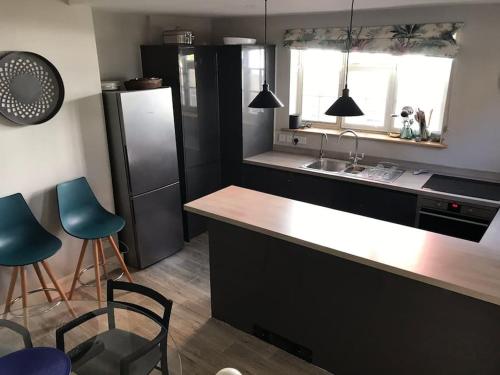 a kitchen with a counter and some blue chairs at Charming property in the heart of Midhurst in Midhurst