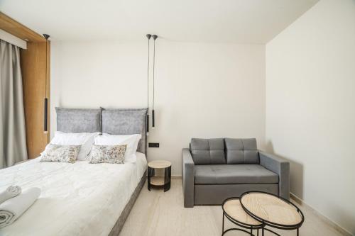 a bedroom with a bed and a chair at Nikon Boutique Hotel in Kalamaki