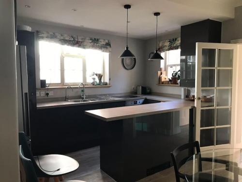 a kitchen with a sink and a counter with chairs at Charming property in the heart of Midhurst in Midhurst