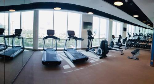 a gym with cardio equipment in a building with windows at One bedroom apartment - DAMAC TOWER in Riyadh