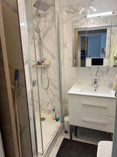 une salle de bain blanche avec une douche et un lavabo dans l'établissement 2-bedroom apartment (60m2), à Ivry-sur-Seine