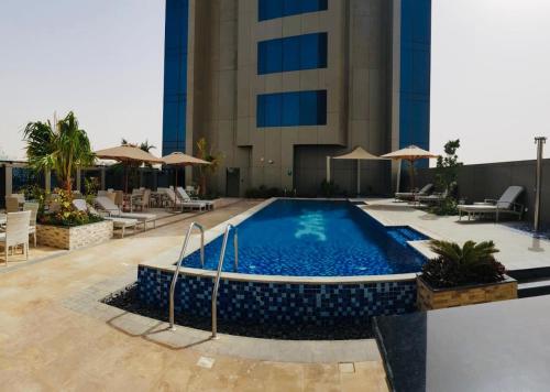 a swimming pool in front of a building at One bedroom apartment - DAMAC TOWER in Riyadh