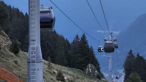 a pair of gondolas on a ski lift in the mountains at Bilocale con box a due passi dalle piste da sci in Colere
