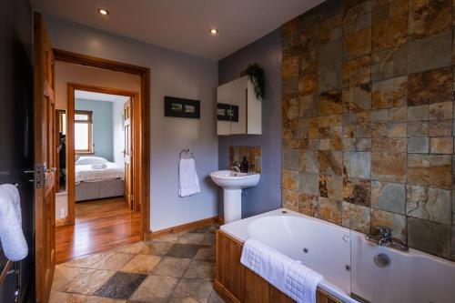 a bathroom with a tub and a sink at Portbahn, Bruichladdich in Bruichladdich