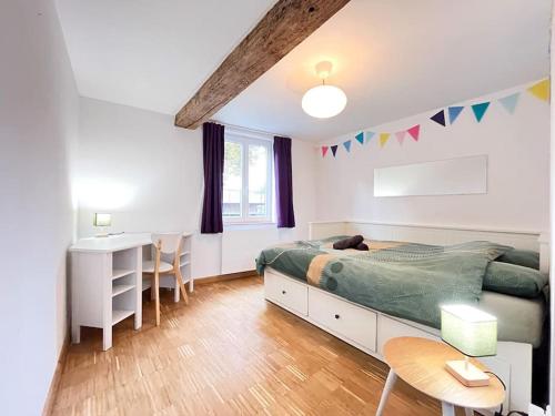 une chambre avec un lit, une table et un bureau dans l'établissement L'amiénoise-6min à pied du centre, à Amiens