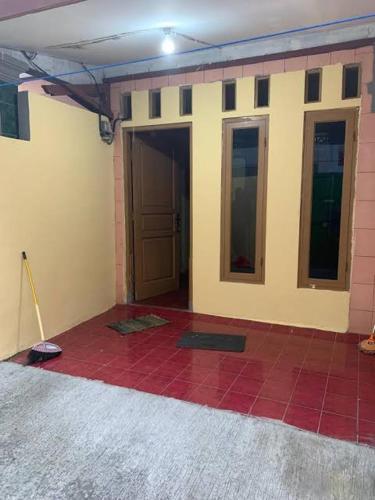 Rumah Evan في جاكرتا: غرفة مع أرضية بلاط حمراء وباب