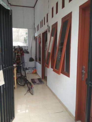 Rumah Evan في جاكرتا: غرفة بها دراجة على جدار مع لوحات
