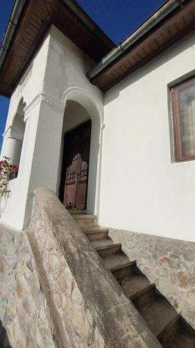 una puerta de un edificio blanco con escaleras delante en Casa Barbulescu, en Vaideeni