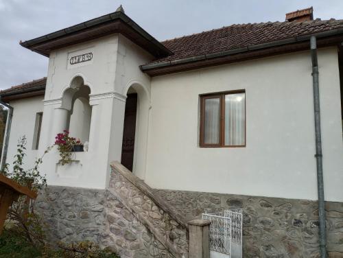 Casa blanca con pared de piedra en Casa Barbulescu, en Vaideeni