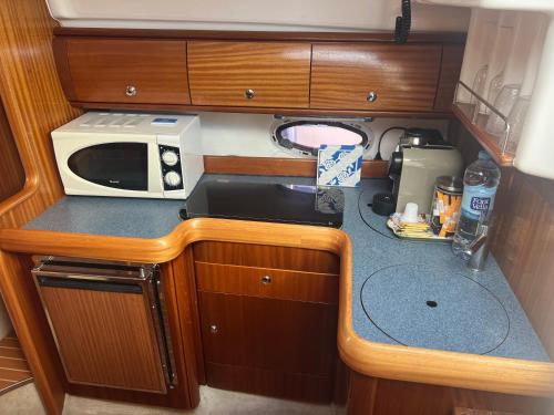 eine kleine Küche mit einer Spüle und einer Mikrowelle in der Unterkunft Maser II ( Excelente Mini Yate ) in Valencia