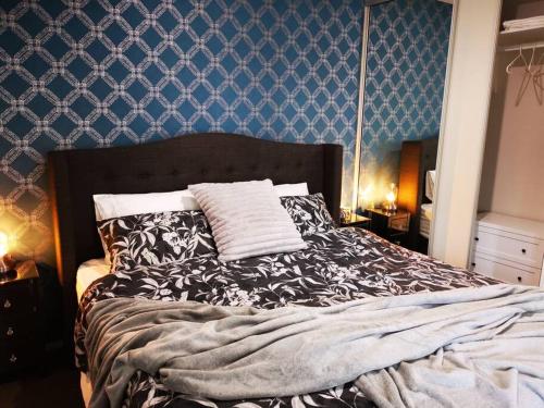 a bedroom with a large bed with blue wallpaper at King on Sturt in Adelaide