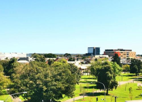 a cityscape of a park with trees and buildings at King on Sturt in Adelaide