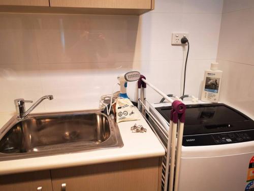 um balcão de cozinha com um lavatório e um aparelho em King on Sturt em Adelaide