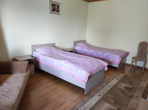 two beds in a room with a couch and a chair at Бархатный Сезон in Cholpon-Ata