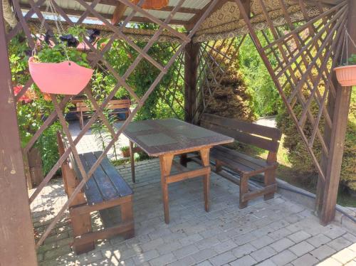 a picnic table and a bench in a gazebo at Бархатный Сезон in Cholpon-Ata