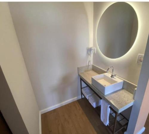 a bathroom with a sink and a mirror at HotBeachSuites Lazer e Diversão in Olímpia