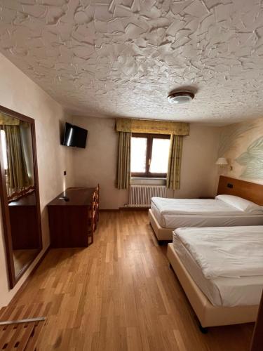 Cette chambre comprend 2 lits et un bureau. dans l'établissement Hotel Breuil, à Breuil-Cervinia