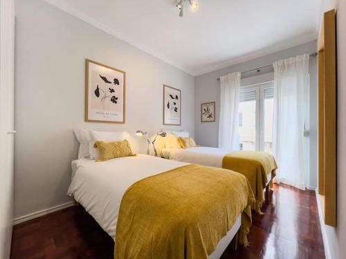1 Schlafzimmer mit 2 Betten und gelben Decken in der Unterkunft Olaias Lisbon 2bed near Metro in Lissabon