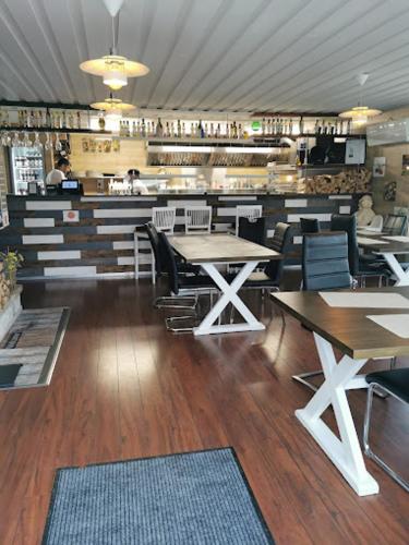 a dining room with tables and chairs in a restaurant at Hotell Lamar in Ängelholm