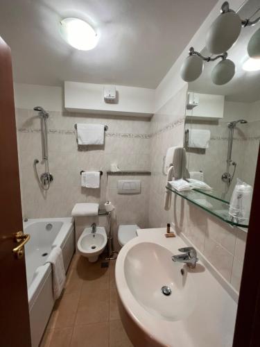 e bagno con lavandino, servizi igienici e vasca. di Hotel Breuil a Breuil-Cervinia