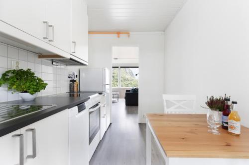 a kitchen with white cabinets and a wooden counter top at Trolltunga Aparthotel in Tysso