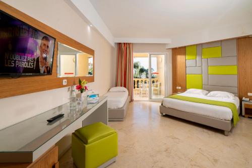 a hotel room with two beds and a tv at Houda Yasmine Marina & SPA in Hammamet