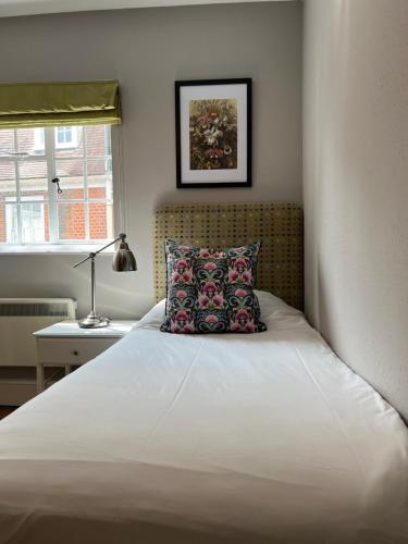 a bedroom with a bed with a pillow and a window at White Horse in Maldon